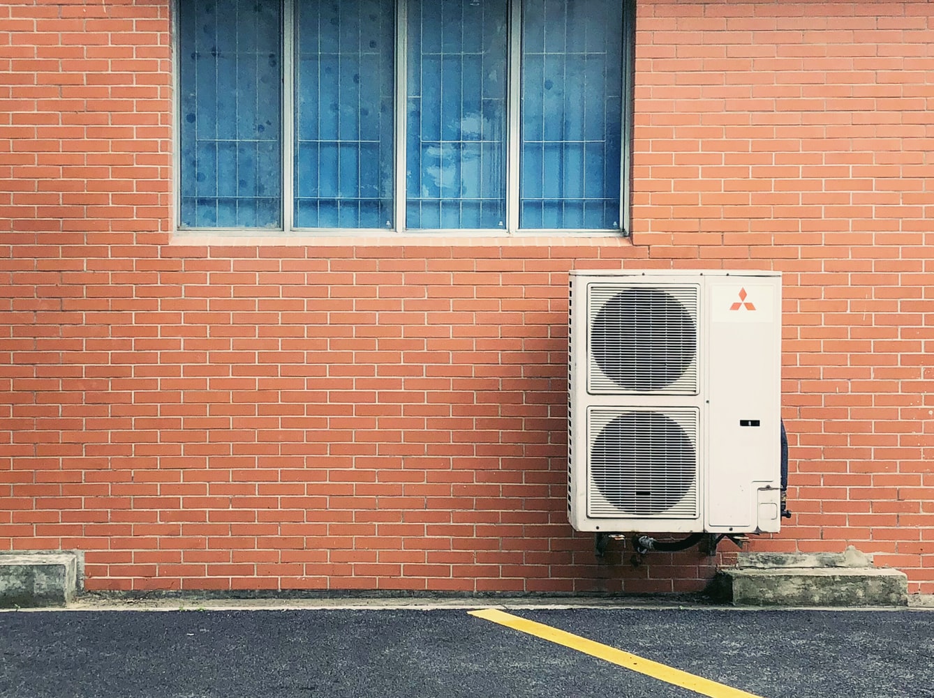 An Air Conditioner Mounted On A Brick Wall On The Sunshine Coast